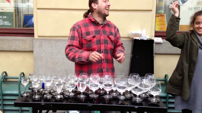 Ce musicien de rue expose plusieurs verres sur une table, ce qu'il fait avec est majestueux !