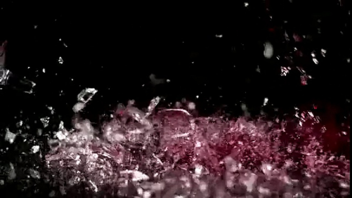 stock footage a glass of red wine falls in slow motion against a black background it shatters as it