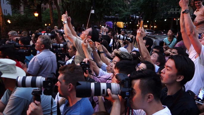 Foule de photographes à Manhattan alors que le soleil s'aligne avec les buildings