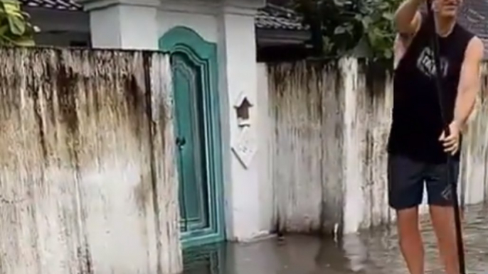 Paddle Boarder Tours Flooded Streets of Bali