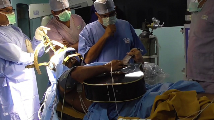 Taskin Ibna Ali, a Dhaka-based musician, plays the guitar to test if the brain surgery on him has restored mobility of his fingers on the left hand at a hospita