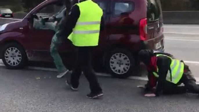 Une voiture force un barrage de gilets jaunes juste devant des gendarmes.