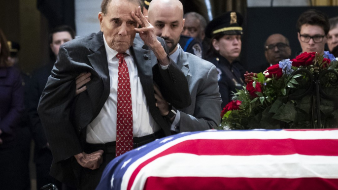 Bob Dole Stands To Salute Former President George H.W. Bush