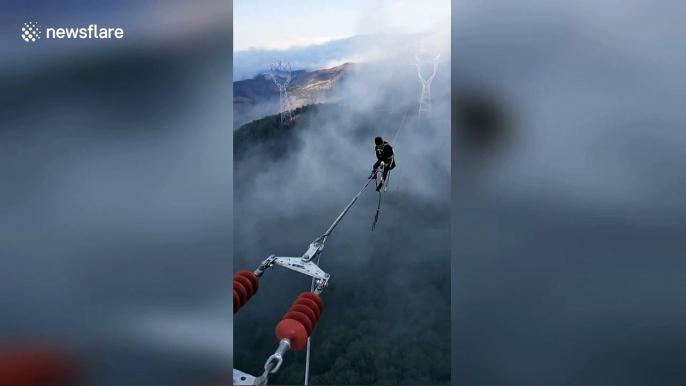 Chinese electricians work on power lines hundreds of feet above the ground