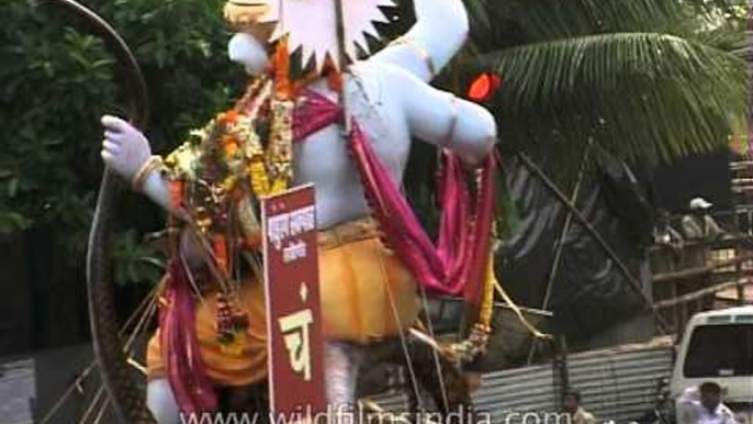 Ganesha devotees walk through busy traffic with the Ganesha Idol