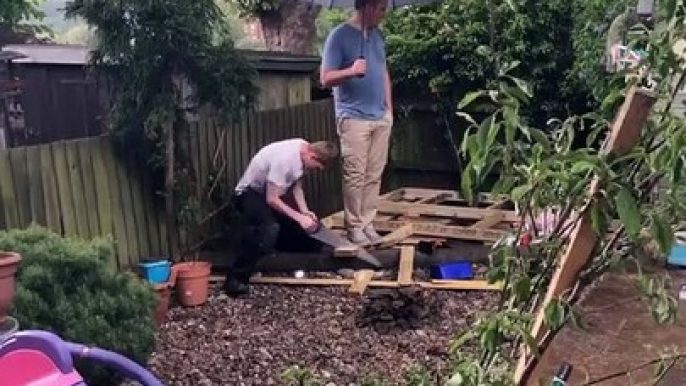 Bricolage : le fils scie et le père tient le parapluie !