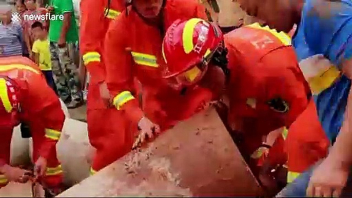 Chinese firefighters rescue worker trapped in a concrete pipe after falling down well