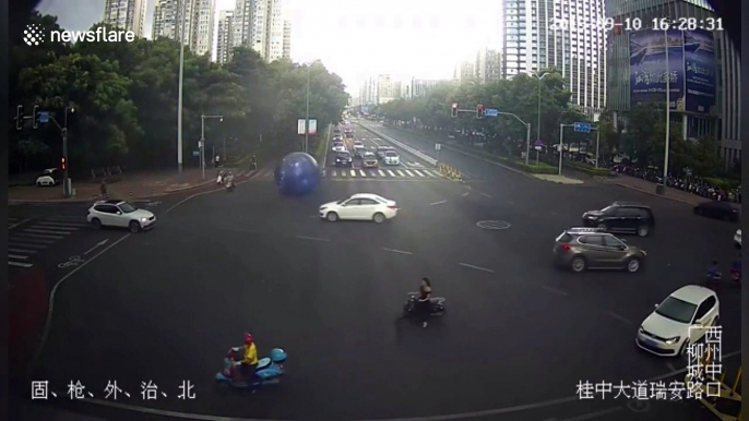 Strong wind blows giant moon-themed balloon onto busy Chinese road