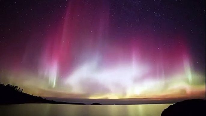 Il filme de magnifiques Aurores Boréales au dessus d'un lac dans le Michigan