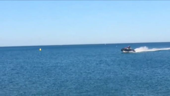 Una lancha que huia de una persecución termina encallando en la arena de una playa abarrotada de turistas