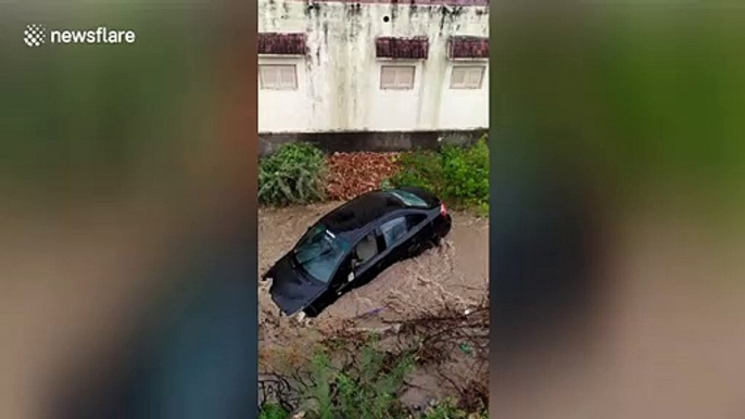 Parked car swept away in India during flash flood