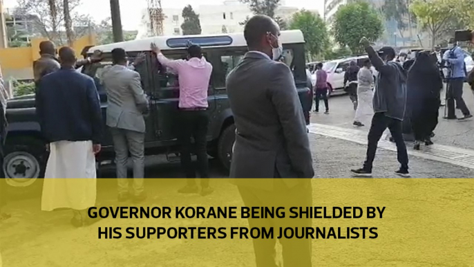 Governor Korane being shielded by his supporters from Journalists