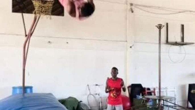 Acrobatic Dunk Team Performs Front Flips Before Slam Dunking Basketball