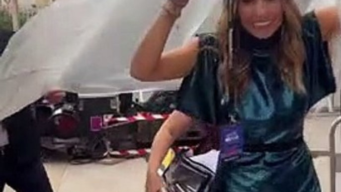 Laury Thilleman évite d'abîmer sa robe sous la pluie à Montpellier, lors de la Fête de la Musique, le 21 juin 2022.