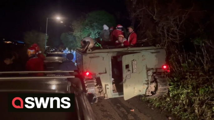 Police were called after a tank full of Santas caused chaos by getting stuck down a village lane during a pub crawl