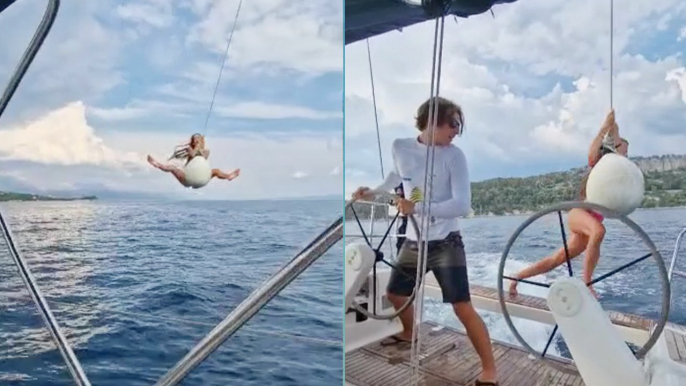 Adventure-seeker caps off her summer by swinging out of boat & splashing into sea