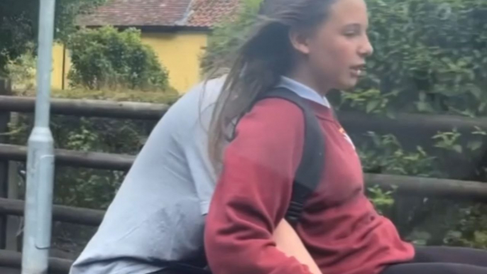 Woman catches son riding a bicycle with his girlfriend seated atop the handlebars