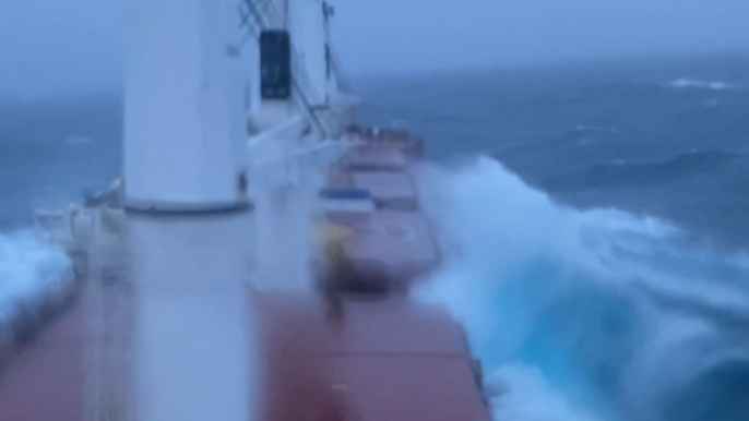 Challenging waves from the Atlantic Ocean breach the deck of cargo ship