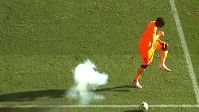 Firecracker explodes near goalkeeper as he falls to ground injured and has to be stretchered off pitch