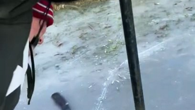 Boy with hockey stick gets his tongue stuck on pole on icy surface