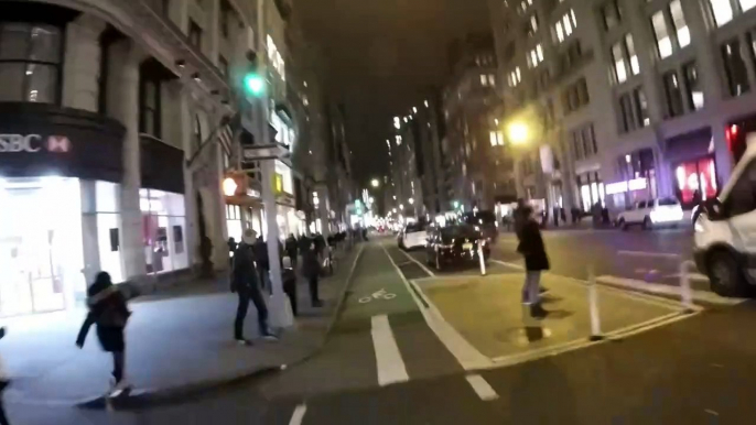 Loud horns blare at bikes and cars, stopping pedestrians in this clip from an evening bike ride in New York City.