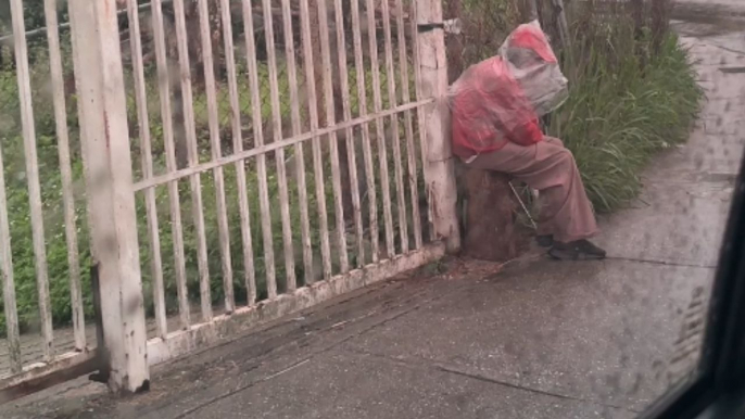 Kindhearted woman helps poor man with breakfast and umbrella during rainstorm