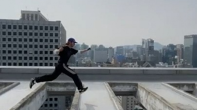 Guy Jumps Over Large Slats on Roof of Skyscraper